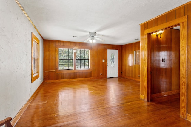 914 S Hill St, Alvin, TX 77511 - foyer entrance featuring wood finished floors, a ceiling fan, wood walls, baseboards, and a textured wall
