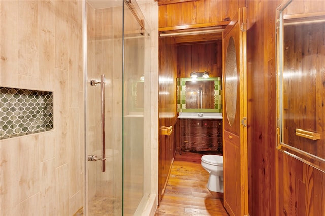 914 S Hill St, Alvin, TX 77511 - bathroom featuring toilet, a shower stall, vanity, hardwood / wood-style floors, and wood walls