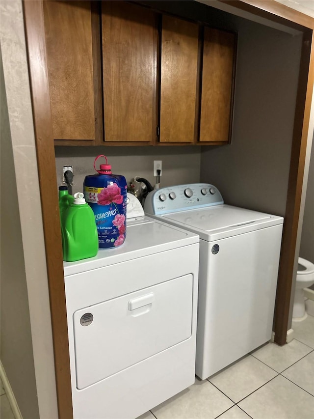 206 Plaza Verde Dr Unit D16, Houston, TX 77038 - laundry area with washing machine and clothes dryer, light tile patterned flooring, and cabinet space