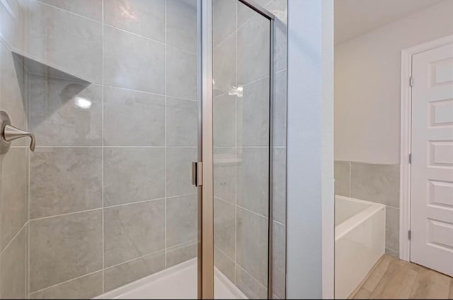 2301 Sereno Shores Dr, Texas City, TX 77568 - full bathroom featuring a stall shower, a bath, and wood finished floors