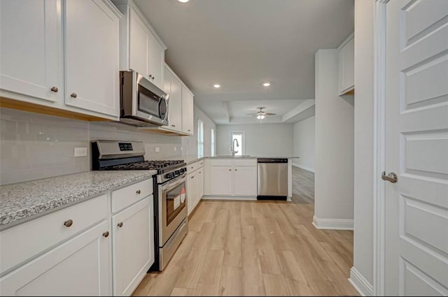 2301 Sereno Shores Dr, Texas City, TX 77568 - kitchen with appliances with stainless steel finishes, a peninsula, decorative backsplash, white cabinetry, and recessed lighting