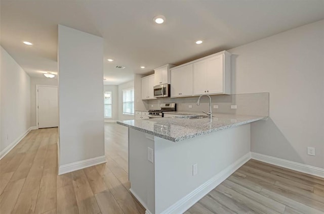 2301 Sereno Shores Dr, Texas City, TX 77568 - kitchen featuring stainless steel appliances, light stone countertops, light wood-style flooring, a sink, and recessed lighting