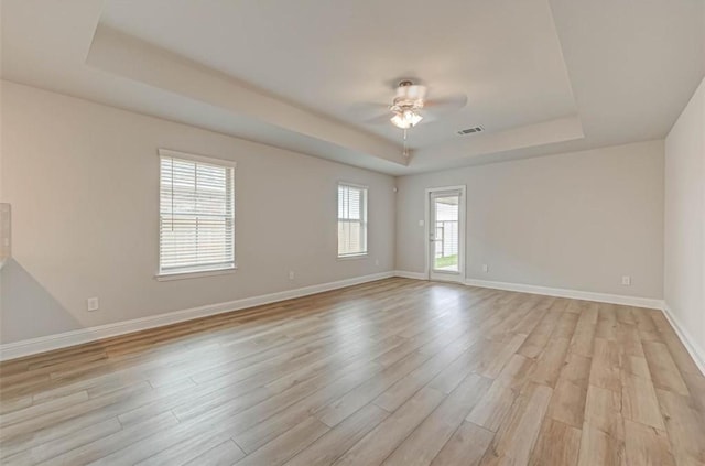 2301 Sereno Shores Dr, Texas City, TX 77568 - unfurnished room featuring a tray ceiling, light wood finished floors, ceiling fan, and baseboards