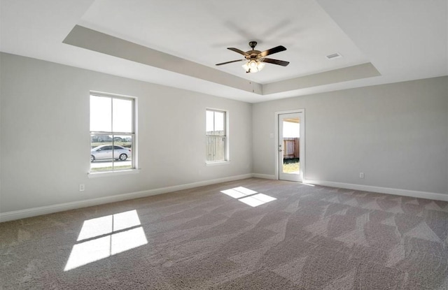 2301 Sereno Shores Dr, Texas City, TX 77568 - empty room featuring a tray ceiling, carpet floors, and plenty of natural light