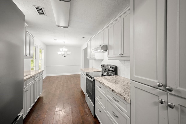 14790 N Tram Rd, Splendora, TX 77372 - kitchen featuring appliances with stainless steel finishes, under cabinet range hood, a chandelier, decorative backsplash, and a textured ceiling