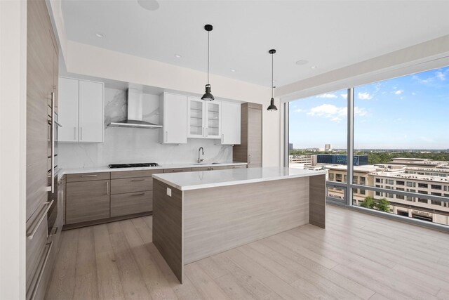 2047 Westcreek Ln Unit 1105, Houston, TX 77027 - kitchen with wall chimney exhaust hood, modern cabinets, a sink, gas stovetop, and light countertops