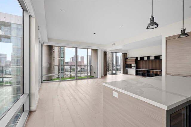 2047 Westcreek Ln Unit 1105, Houston, TX 77027 - unfurnished living room featuring a city view and light wood-style flooring