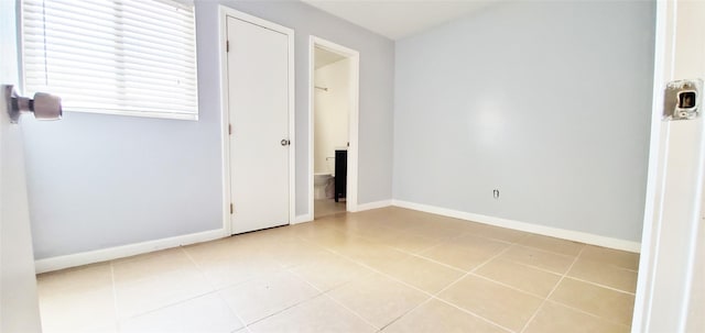 1603 Welch St, Houston, TX 77006 - unfurnished bedroom featuring tile patterned flooring, baseboards, and ensuite bath