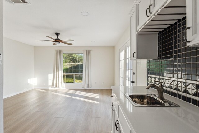 3012 Monument Dr, Round Rock, TX 78681 - kitchen featuring a sink, baseboards, ceiling fan, open floor plan, and light wood finished floors