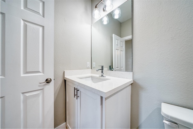 502 W Francis St, Baytown, TX 77520 - half bathroom featuring vanity, toilet, and a textured wall