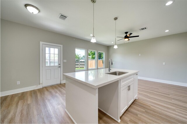 502 W Francis St, Baytown, TX 77520 - kitchen featuring a sink, light wood-style floors, white cabinetry, baseboards, and recessed lighting