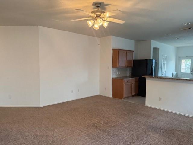5417 Summer Spring Ln, Rosharon, TX 77583 - unfurnished living room featuring ceiling fan, light colored carpet, and baseboards