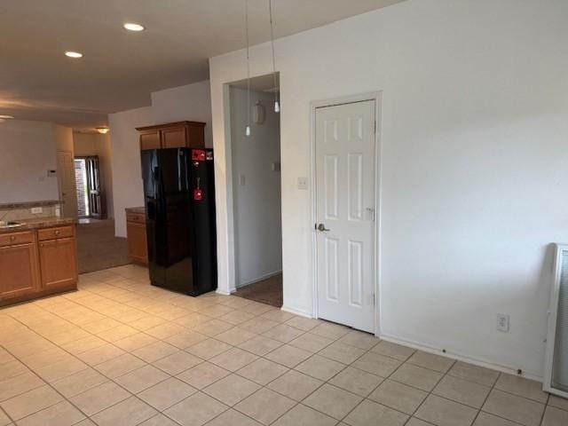 5417 Summer Spring Ln, Rosharon, TX 77583 - kitchen featuring black fridge, light tile patterned flooring, recessed lighting, brown cabinetry, and pendant lighting