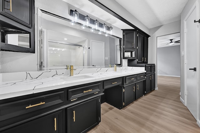 20006 18th Fairway Dr, Humble, TX 77346 - full bath with a stall shower, double vanity, ceiling fan, wood finished floors, and baseboards