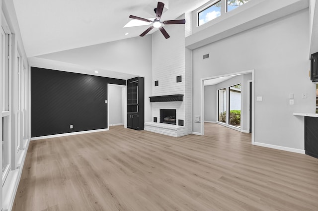20006 18th Fairway Dr, Humble, TX 77346 - unfurnished living room with high vaulted ceiling, a ceiling fan, plenty of natural light, a brick fireplace, and baseboards