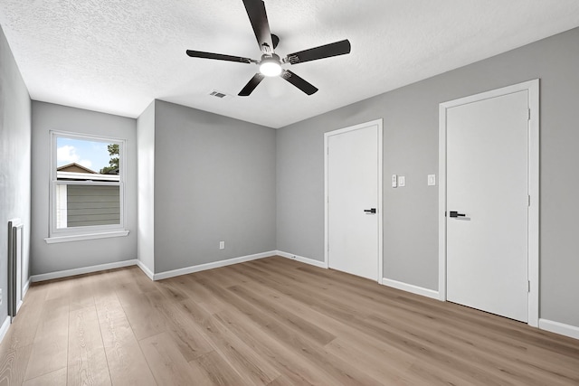 20006 18th Fairway Dr, Humble, TX 77346 - unfurnished bedroom featuring light wood-style flooring, a textured ceiling, baseboards, and a ceiling fan