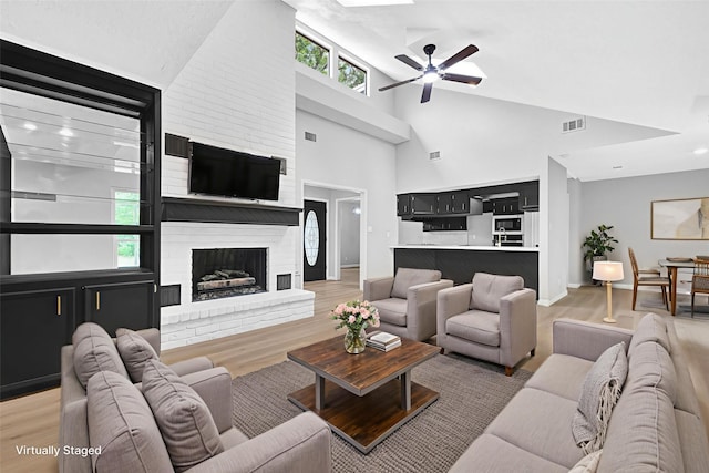 20006 18th Fairway Dr, Humble, TX 77346 - living area featuring a ceiling fan, light wood-type flooring, high vaulted ceiling, a fireplace, and baseboards