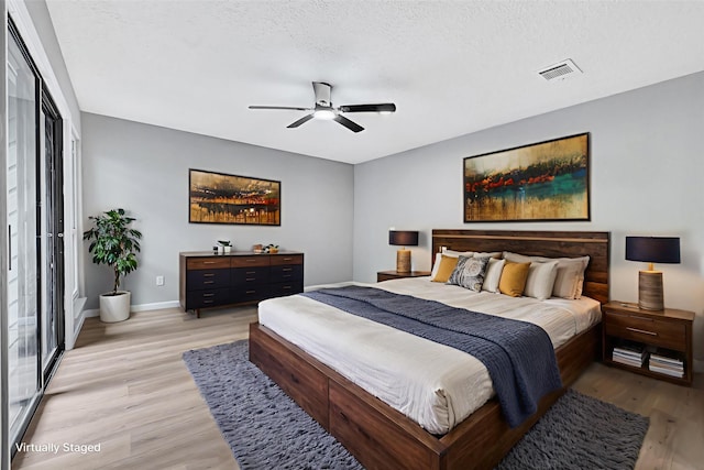 20006 18th Fairway Dr, Humble, TX 77346 - bedroom featuring light wood-style flooring, baseboards, a ceiling fan, and a textured ceiling