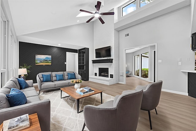 20006 18th Fairway Dr, Humble, TX 77346 - living area with high vaulted ceiling, a fireplace, healthy amount of natural light, a ceiling fan, and light wood finished floors