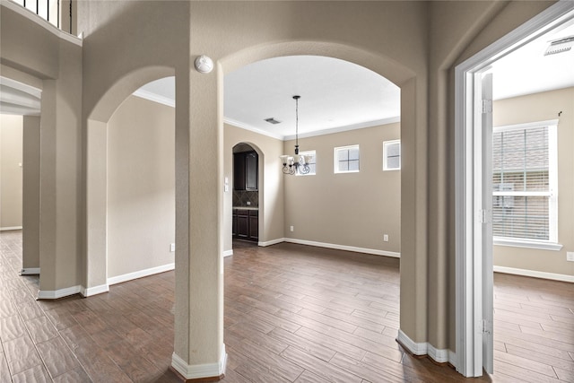 23918 Windsor Canyon Ct, Spring, TX 77389 - spare room with arched walkways, dark wood-style flooring, ornamental molding, a smoke detector, and baseboards