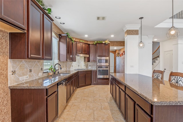 9431 Copper Cove Ln, Rosharon, TX 77583 - kitchen with appliances with stainless steel finishes, a sink, a kitchen island, tasteful backsplash, and light stone countertops