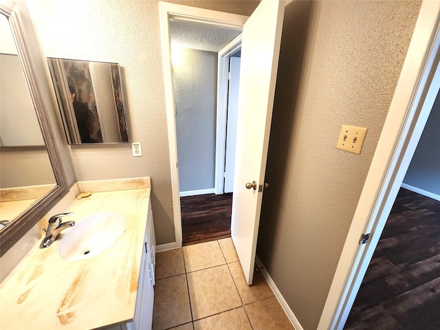 1516 Bay Area Blvd Unit J9, Houston, TX 77058 - bathroom featuring vanity, a textured wall, tile patterned flooring, and baseboards