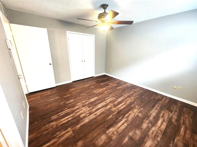 1516 Bay Area Blvd Unit J9, Houston, TX 77058 - unfurnished bedroom with dark wood-style floors, baseboards, a textured ceiling, a closet, and ceiling fan