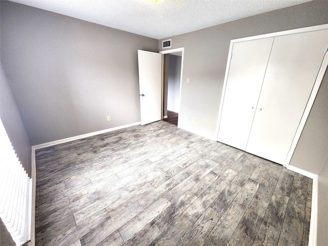 1516 Bay Area Blvd Unit J9, Houston, TX 77058 - unfurnished bedroom with wood finished floors, a closet, and a textured ceiling