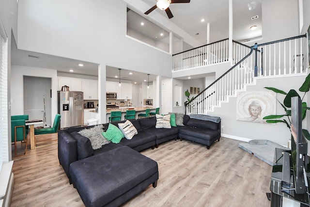 8219 Oxbow Manor Ln, Cypress, TX 77433 - living area featuring a high ceiling, a ceiling fan, light wood finished floors, stairway, and recessed lighting