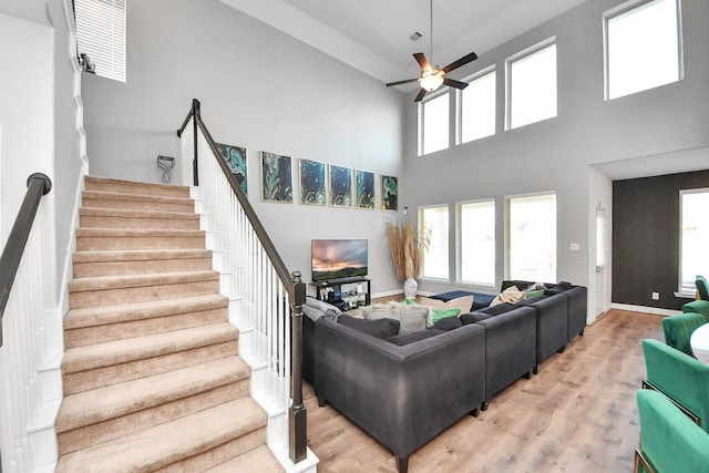 8219 Oxbow Manor Ln, Cypress, TX 77433 - living room featuring ceiling fan, wood finished floors, a high ceiling, stairs, and baseboards
