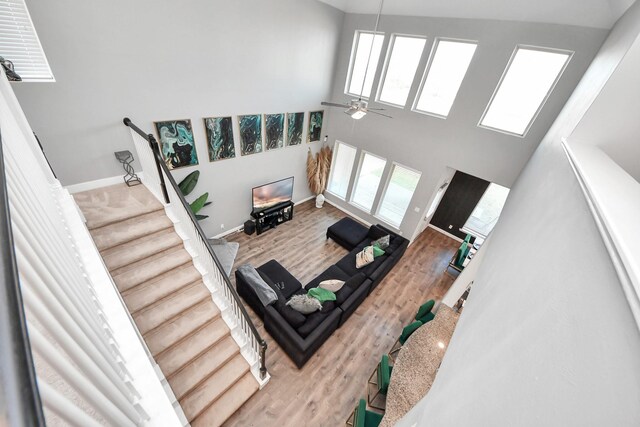 8219 Oxbow Manor Ln, Cypress, TX 77433 - living area featuring healthy amount of natural light, wood finished floors, a ceiling fan, baseboards, and a high ceiling