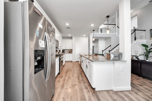 8219 Oxbow Manor Ln, Cypress, TX 77433 - kitchen with stainless steel appliances, a sink, light wood-type flooring, white cabinetry, and tasteful backsplash