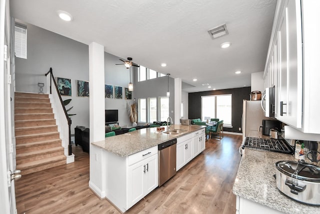 8219 Oxbow Manor Ln, Cypress, TX 77433 - kitchen featuring appliances with stainless steel finishes, a sink, light wood-style floors, white cabinets, and recessed lighting