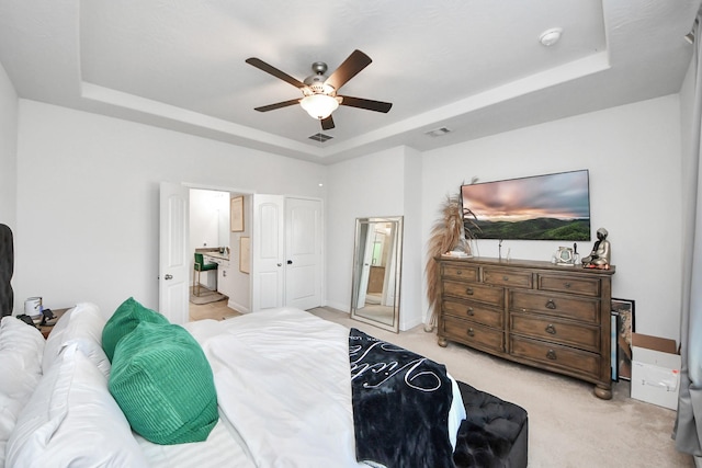 8219 Oxbow Manor Ln, Cypress, TX 77433 - bedroom featuring a tray ceiling, light carpet, a ceiling fan, and connected bathroom