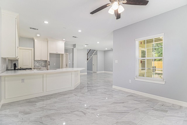 4801 Marquita Ln, Houston, TX 77039 - kitchen featuring light countertops, ceiling fan, light marble finish flooring, backsplash, and a peninsula