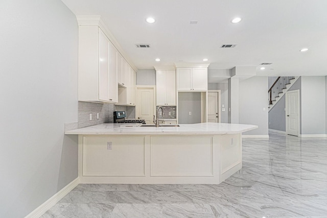 4801 Marquita Ln, Houston, TX 77039 - kitchen featuring a sink, light marble finish floors, a peninsula, stove, and baseboards