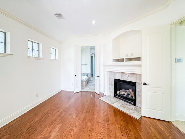 5302 Briarwick Meadow Ln, Sugar Land, TX 77479 - unfurnished living room featuring ornamental molding, wood finished floors, a tile fireplace, baseboards, and recessed lighting