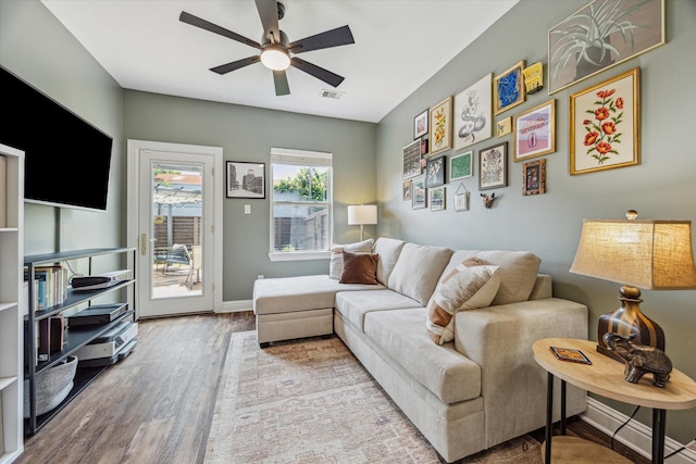 1250 Sampson St, Houston, TX 77003 - living room featuring wood finished floors, a ceiling fan, and baseboards
