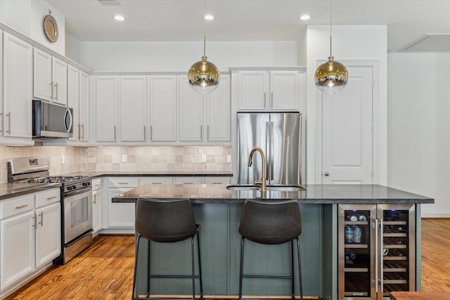 1250 Sampson St, Houston, TX 77003 - kitchen with stainless steel appliances, a sink, decorative backsplash, a breakfast bar area, and light wood-style flooring