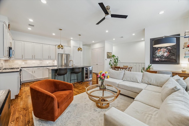 1250 Sampson St, Houston, TX 77003 - living room featuring beverage cooler, a ceiling fan, wood finished floors, and recessed lighting