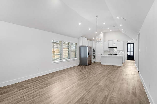 21318 Oakley Claremont Ct, Magnolia, TX 77355 - kitchen with appliances with stainless steel finishes, open floor plan, a chandelier, backsplash, and white cabinetry