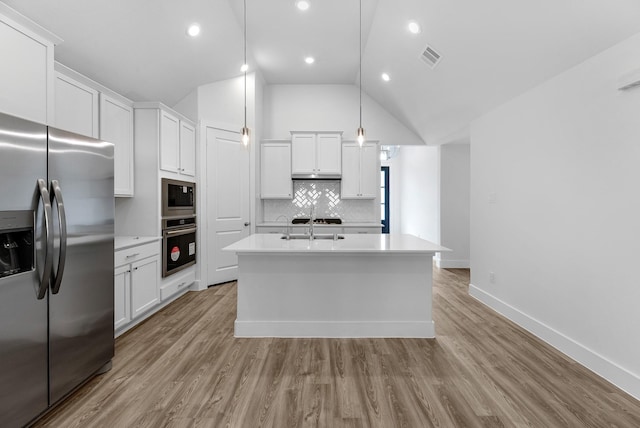 21318 Oakley Claremont Ct, Magnolia, TX 77355 - kitchen with stainless steel appliances, a kitchen island with sink, backsplash, light countertops, and white cabinets