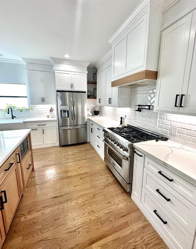5018 Darling St, Houston, TX 77007 - kitchen with stainless steel appliances, decorative backsplash, light stone countertops, light wood-type flooring, and a sink