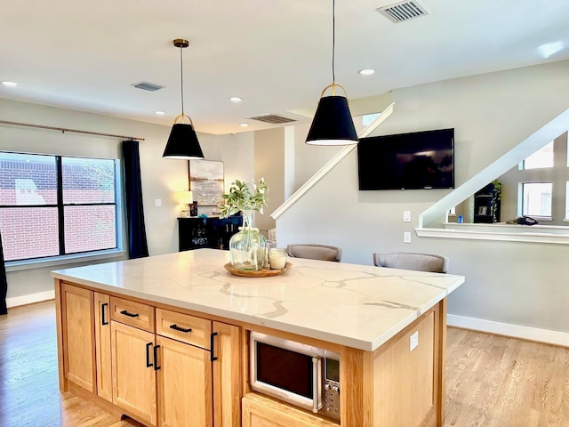 5018 Darling St, Houston, TX 77007 - kitchen featuring stainless steel microwave, light wood finished floors, light stone counters, plenty of natural light, and recessed lighting
