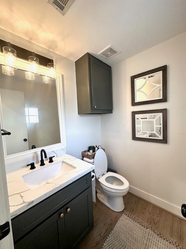 5018 Darling St, Houston, TX 77007 - bathroom featuring toilet, vanity, wood finished floors, and baseboards