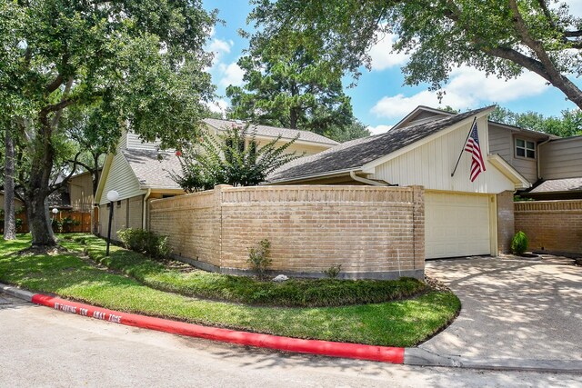 8028 Oakwood Forest Dr, Houston, TX 77040 - view of side of property featuring a garage, brick siding, concrete driveway, and roof with shingles