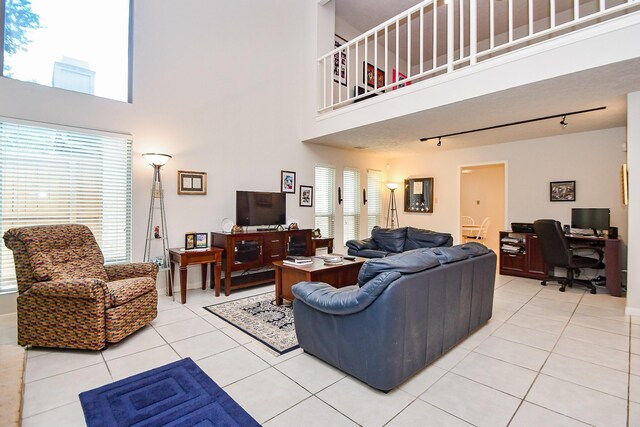 8028 Oakwood Forest Dr, Houston, TX 77040 - living room with light tile patterned flooring, an office area, a high ceiling, and rail lighting