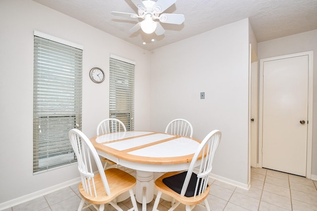 8028 Oakwood Forest Dr, Houston, TX 77040 - dining area with light tile patterned floors, ceiling fan, baseboards, and a textured ceiling