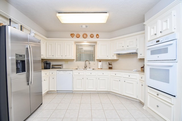 8028 Oakwood Forest Dr, Houston, TX 77040 - kitchen featuring white appliances, a sink, under cabinet range hood, light countertops, and a textured ceiling