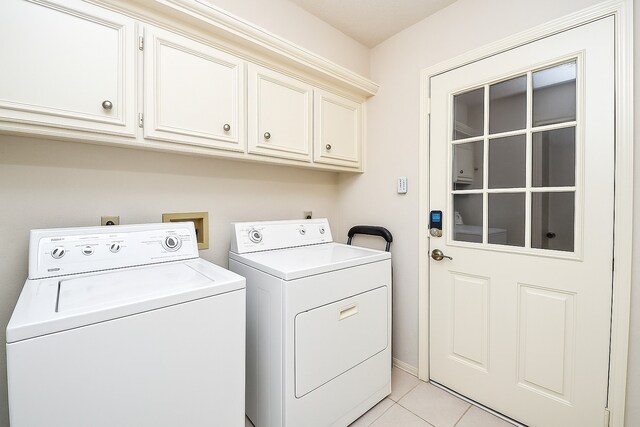 8028 Oakwood Forest Dr, Houston, TX 77040 - washroom featuring cabinet space, washing machine and clothes dryer, and light tile patterned flooring